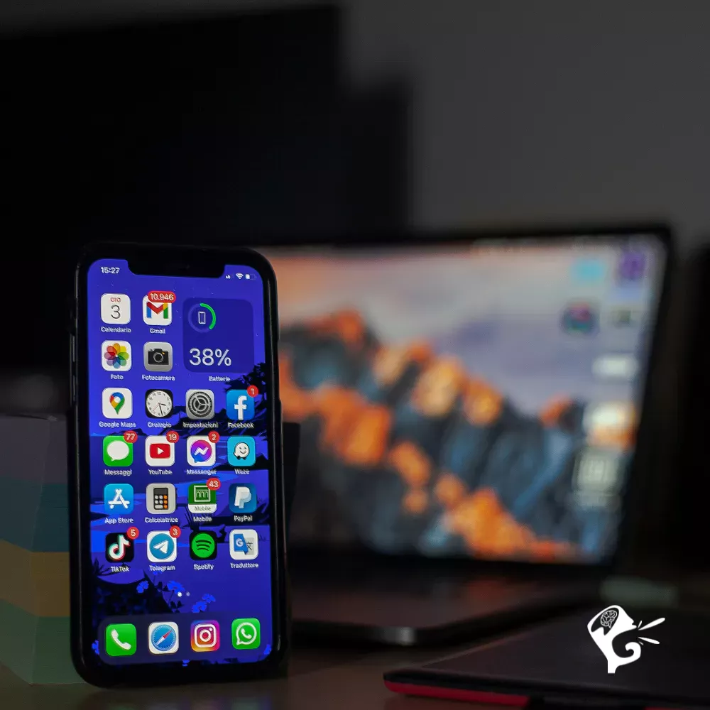 Smartphone affichant un écran iOS avec applications mobiles, illustrant la gestion de sites web restaurant via un CMS mobile-friendly